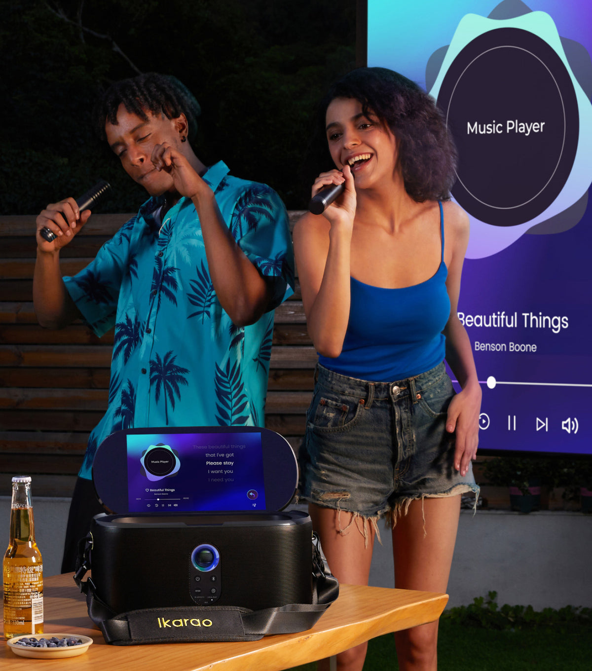 Two friends singing outdoors with an Ikarao karaoke machine